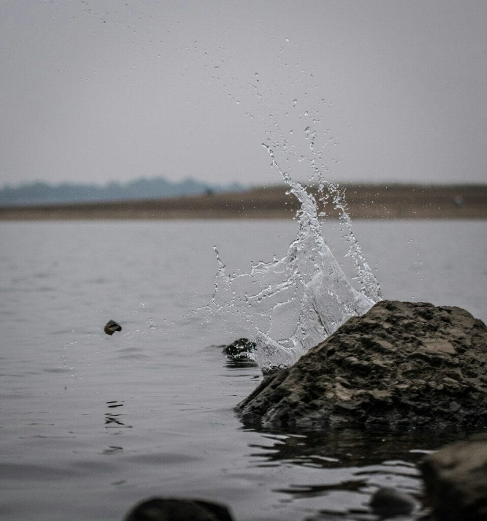 water splash on brown rock during daytime