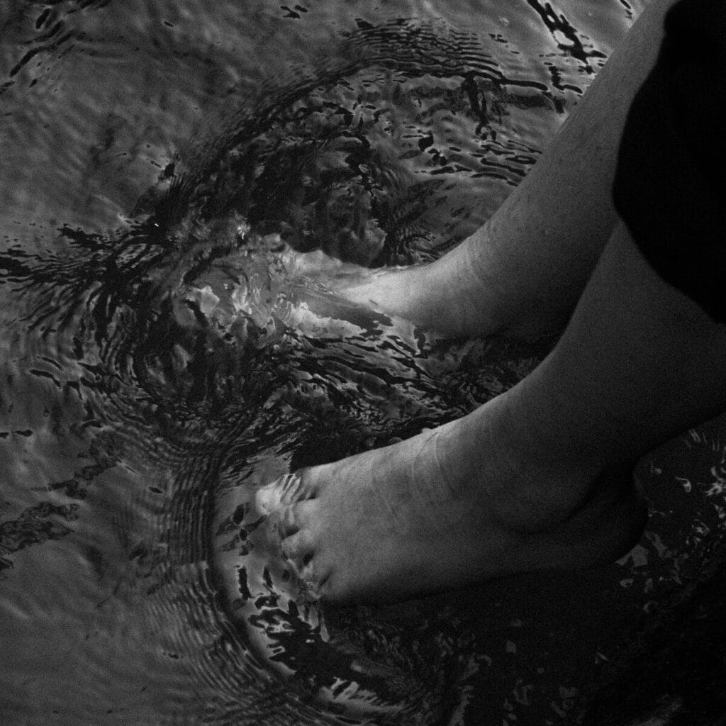 Bare feet wading through swirling water