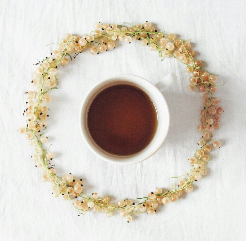 White currants form a circle around a cup of tea